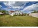 Expansive backyard featuring lush lawn, white picket fence, and bright sunshine, creating a serene outdoor space at 723 Palma Dr, Lady Lake, FL 32159