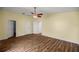 Bedroom with wood-look floors, ceiling fan, and multiple doors for easy access at 723 Palma Dr, Lady Lake, FL 32159