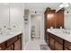 Elegant bathroom featuring dual sinks, cabinetry, and walk-in shower with decorative tile at 879 Pisano Way, The Villages, FL 32163