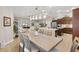 Dining area with wood table and chairs next to the kitchen and a view into the living room at 879 Pisano Way, The Villages, FL 32163