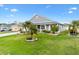 Beautiful home with lush lawn and manicured landscaping. Palm trees add a tropical touch at 879 Pisano Way, The Villages, FL 32163