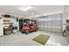 Well-organized garage featuring a golf cart, workbench, and epoxy floors at 879 Pisano Way, The Villages, FL 32163