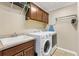 Practical laundry room with a sink, cabinetry, washer, and dryer at 879 Pisano Way, The Villages, FL 32163