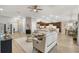 Inviting living room flowing into kitchen and dining areas, featuring neutral tones and stylish furnishings at 879 Pisano Way, The Villages, FL 32163