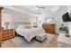 Serene main bedroom with tray ceiling, light wood floors, and neutral decor at 879 Pisano Way, The Villages, FL 32163