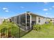 A covered patio with a screened enclosure provides outdoor dining and relaxation space at 879 Pisano Way, The Villages, FL 32163