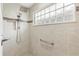 Modern shower with rainfall showerhead, hand bar, and tile surround at 879 Pisano Way, The Villages, FL 32163