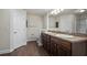 Bathroom featuring double sinks with granite countertops and dark wood cabinets at 902 Chestnut Dr, Fruitland Park, FL 34731