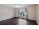 A neutral bedroom with a ceiling fan and large window overlooking the backyard at 902 Chestnut Dr, Fruitland Park, FL 34731