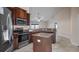 Well-lit kitchen with stainless steel appliances, a central island, and granite countertops at 902 Chestnut Dr, Fruitland Park, FL 34731