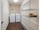 Functional laundry room equipped with a washer, dryer, and spacious wire shelving units at 902 Chestnut Dr, Fruitland Park, FL 34731