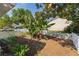 Private backyard with lush greenery, a white fence, and mature trees at 1013 Lake Elsie Dr, Tavares, FL 32778