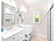 Bright bathroom with double sinks, white vanities, white cabinets, and a glass-enclosed shower at 1013 Lake Elsie Dr, Tavares, FL 32778