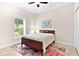 Bright bedroom with a wooden bed frame, colorful rug, and natural light from the window at 1013 Lake Elsie Dr, Tavares, FL 32778