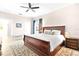 Inviting bedroom with a wood sleigh bed, neutral walls, a ceiling fan, and a classic rug at 1013 Lake Elsie Dr, Tavares, FL 32778