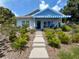 Beautiful home with a blue awning, complemented by lush landscaping and a welcoming walkway at 1013 Lake Elsie Dr, Tavares, FL 32778