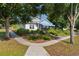 Charming home featuring a blue awning, complemented by lush landscaping and a welcoming walkway at 1013 Lake Elsie Dr, Tavares, FL 32778