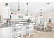Bright kitchen with white cabinetry, granite countertops, and stainless steel appliances, flowing into a dining area at 1013 Lake Elsie Dr, Tavares, FL 32778