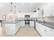 Spacious kitchen with white cabinets, granite countertops, stainless appliances, and wood-look flooring at 1013 Lake Elsie Dr, Tavares, FL 32778
