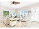 Inviting living room with bright windows, cozy seating, and a view of the porch awning at 1013 Lake Elsie Dr, Tavares, FL 32778