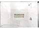 Elegant walk-in shower featuring marble-look tiles, a built-in niche, and a modern shower head at 1013 Lake Elsie Dr, Tavares, FL 32778