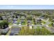 An aerial view shows homes nestled in a well-maintained neighborhood with mature trees and green lawns at 1029 Soledad Way, The Villages, FL 32159