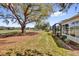Expansive backyard with a large shade tree and views of the community golf course beyond at 1029 Soledad Way, The Villages, FL 32159