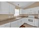 Bright kitchen with white cabinets, appliances, and a window at 1029 Soledad Way, The Villages, FL 32159