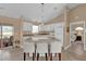 Well-lit kitchen with white cabinetry, stone countertops, and a breakfast bar with seating at 1029 Soledad Way, The Villages, FL 32159
