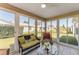 Relaxing sunroom with wicker seating, tiled floors, and multiple windows for enjoying peaceful garden views at 1100 Blythe Way, The Villages, FL 32162