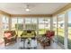 Cozy sunroom with tiled floor, wicker furniture, and large windows offering serene outdoor views at 1100 Blythe Way, The Villages, FL 32162