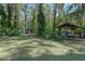 A spacious backyard with lush landscaping, a storage shed and a boat house at 11215 Dead River Rd, Tavares, FL 32778