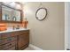 Bathroom with a wood vanity, decorative mirrors, and neutral-colored walls, creating a warm and inviting space at 11215 Dead River Rd, Tavares, FL 32778