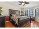 Bedroom featuring a large dark wood bed set, dark wood floors, water view, and ceiling fan at 11215 Dead River Rd, Tavares, FL 32778