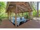 This is a covered boat house with a pontoon boat docked inside it at 11215 Dead River Rd, Tavares, FL 32778