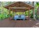 This is a covered boat house with a twin engine pontoon boat docked inside it at 11215 Dead River Rd, Tavares, FL 32778