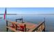 Lake view from a private wooden dock with red Adirondack chairs and American flag at 11215 Dead River Rd, Tavares, FL 32778