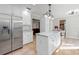 Bright kitchen with stainless steel refrigerator, marble counters, and kitchen island at 11215 Dead River Rd, Tavares, FL 32778