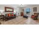 Warm living room featuring cozy seating, neutral walls, shutters, and a glimpse into the bedroom at 11215 Dead River Rd, Tavares, FL 32778