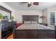 Well-appointed primary bedroom with a large bed frame, elegant dresser, and wood floors for a refined ambiance at 11215 Dead River Rd, Tavares, FL 32778