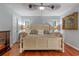 This bedroom features a ceiling fan, wood floors, two windows, and artwork at 11215 Dead River Rd, Tavares, FL 32778