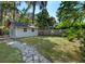 Outbuilding in landscaped backyard with walkway at 11215 Dead River Rd, Tavares, FL 32778