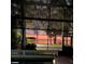 Screened-in patio offers beautiful sunset views of the water and outdoor seating area at 11215 Dead River Rd, Tavares, FL 32778