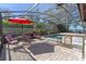 Covered patio with an outdoor bar, grill, and seating area by the pool under a screened enclosure at 11215 Dead River Rd, Tavares, FL 32778