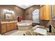 Elegant bathroom with double vanities, a soaking tub, granite countertops, and a window for natural light at 12127 Cypress Landing Ave, Clermont, FL 34711