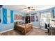 Cozy bedroom with light blue walls, a window, and furnished with wooden furniture at 12127 Cypress Landing Ave, Clermont, FL 34711