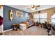 Comfortable bedroom featuring blue accent wall, a window, desk, and a comfortable seating area at 12127 Cypress Landing Ave, Clermont, FL 34711