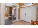 Inviting entryway featuring double doors, tile flooring, and an adjacent room with a comfortable seating area at 12127 Cypress Landing Ave, Clermont, FL 34711