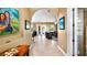Hallway leading to the living room, featuring tile flooring, an arched doorway, and natural light at 12127 Cypress Landing Ave, Clermont, FL 34711