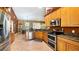Well-lit kitchen featuring wooden cabinets, stainless steel appliances, granite countertops and tiled floors at 12127 Cypress Landing Ave, Clermont, FL 34711